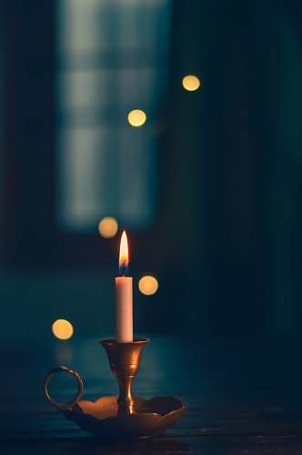 new delhi white candle lit on brass candle holder india